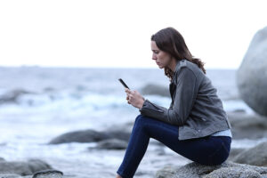 A woman struggles with social media addiction and uses social media on her phone.