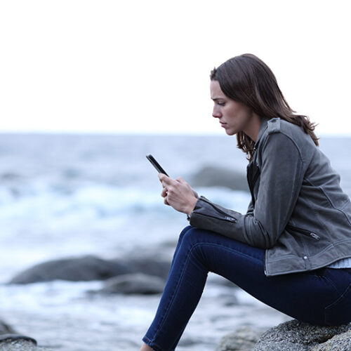 A woman struggles with social media addiction and uses social media on her phone.